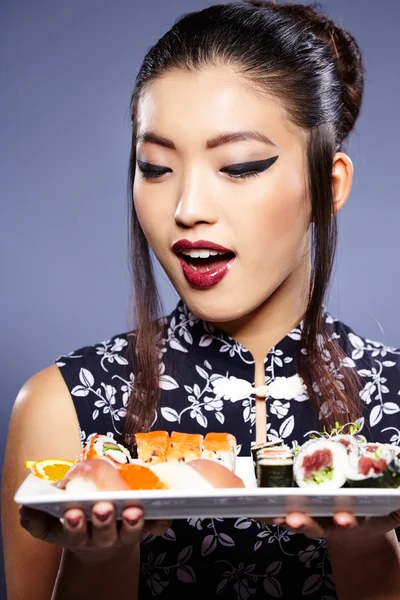 Sushi-Frau hält Sushi mit Essstäbchen in die Kamera — Stockfoto