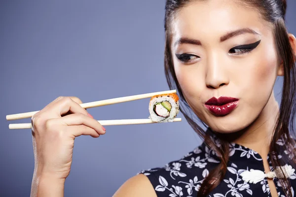 Sushi-Frau hält Sushi mit Essstäbchen in die Kamera — Stockfoto