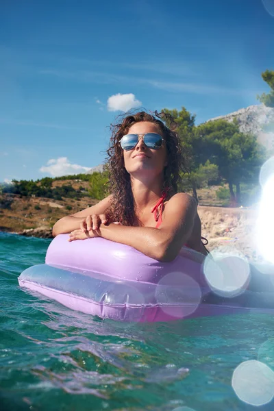Woman relaxing on inflatable mattress. — Stock Photo, Image