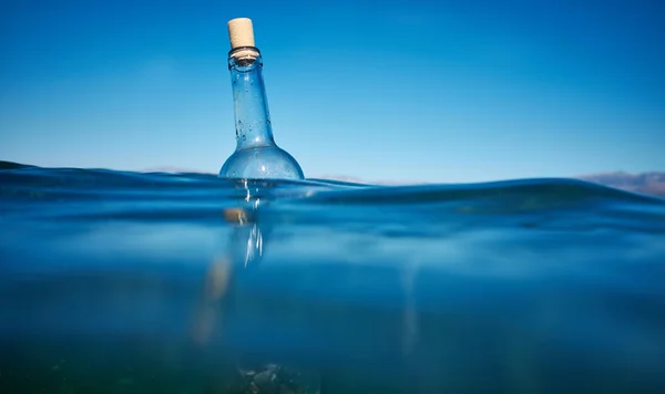 Bottle with a message in water — Stock Photo, Image