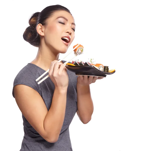 Frau hält Sushi mit Essstäbchen — Stockfoto