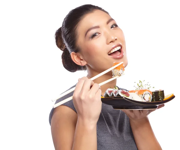Kvinna anläggning sushi med pinnar — Stockfoto