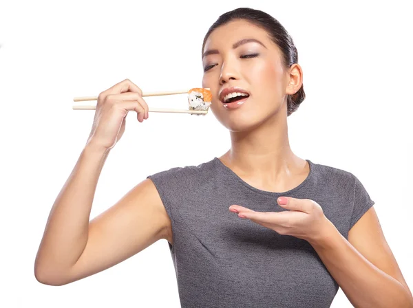 Frau hält Sushi mit Essstäbchen — Stockfoto