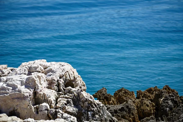 Камни, море и голубая вода фон — стоковое фото