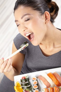 Young woman eating sushi clipart
