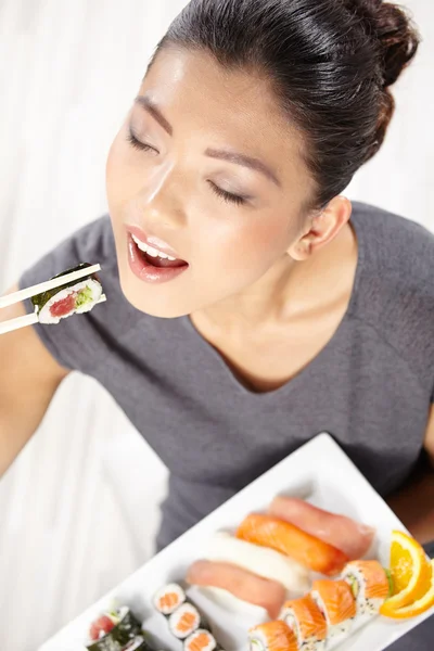Giovane donna mangiare sushi — Foto Stock