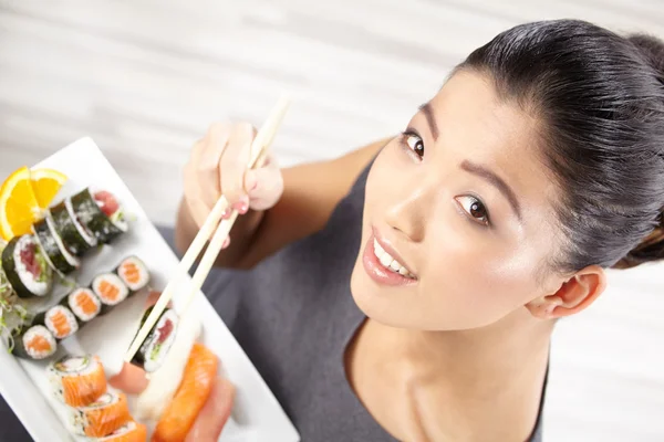 Giovane donna mangiare sushi — Foto Stock