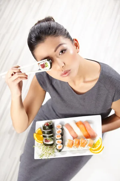 Mladá žena jíst sushi — Stock fotografie