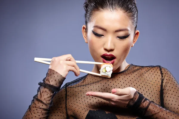 Donna che tiene sushi con le bacchette — Foto Stock