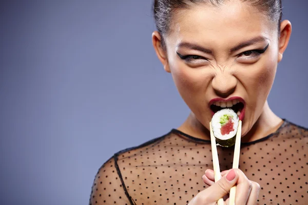 Žena hospodářství sushi hůlkami — Stock fotografie