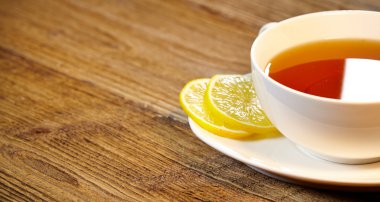 Ahşap masa üzerinde limonlu çay fincan