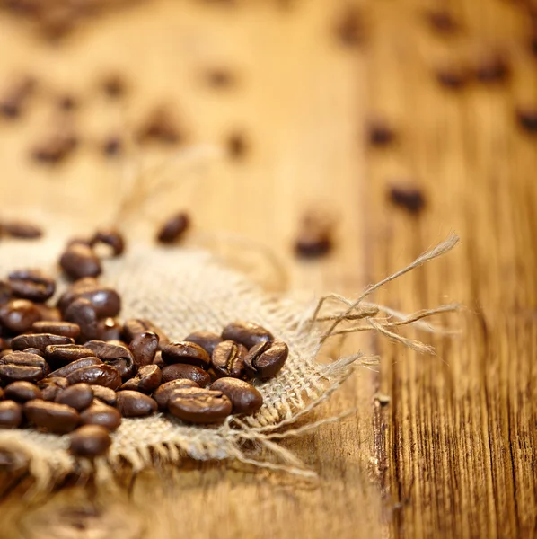 Chicchi di caffè fresco su fondo legno, Macro primo piano per il design — Foto Stock