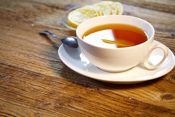 Taza de té con limón en la mesa de madera —  Fotos de Stock