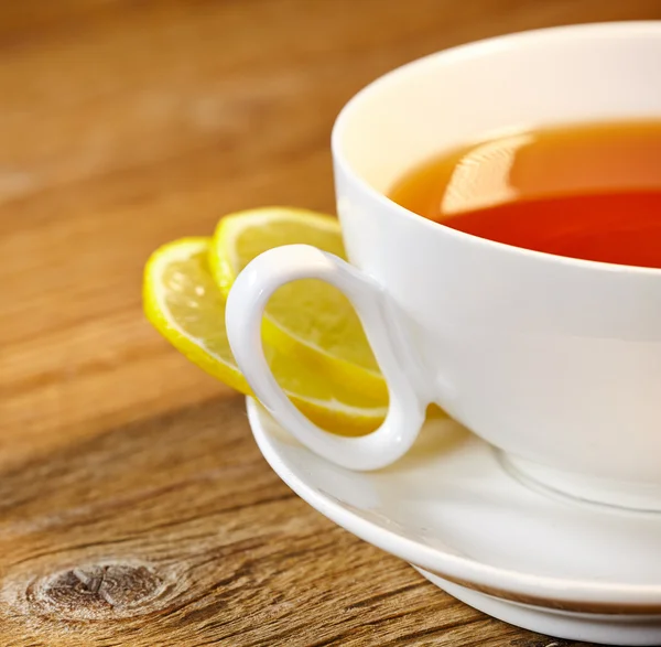 Šálek čaje s citronem na dřevěný stůl — Stock fotografie