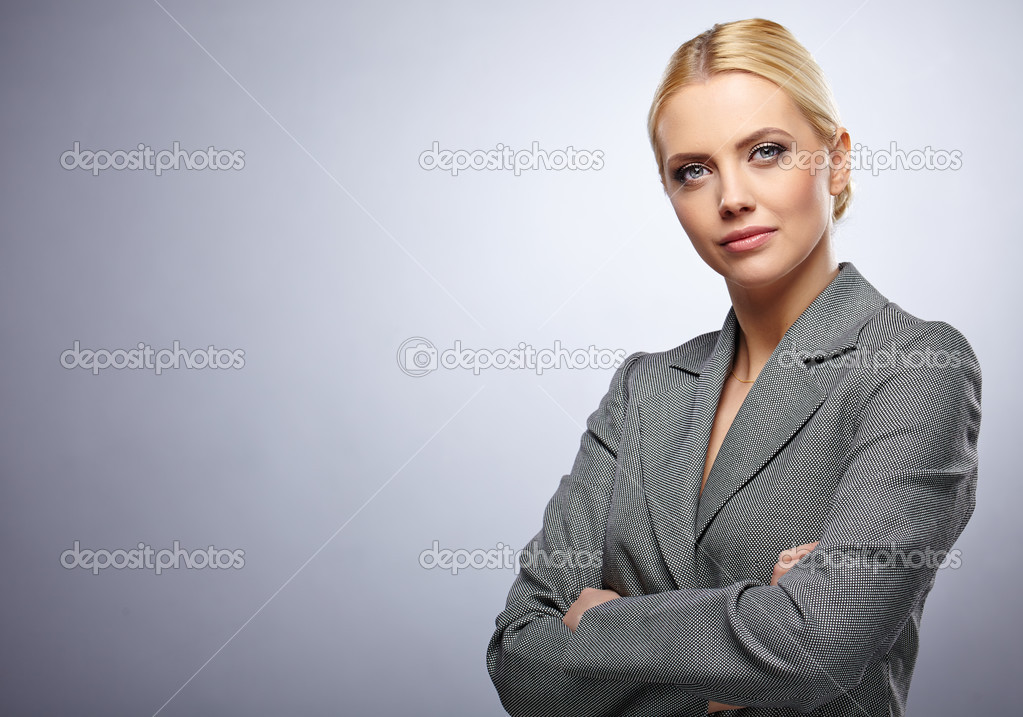 Portrait of a beautiful young business woman standing against gr