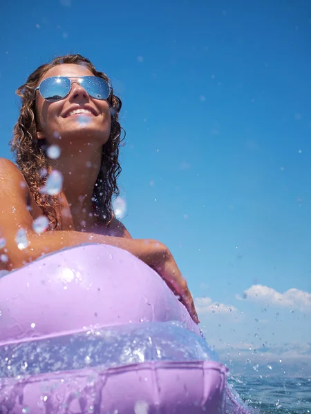 Vrouw op een lucht matras in de zee — Stockfoto