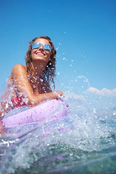 Woman on pink air bed in sea — Stock Photo, Image