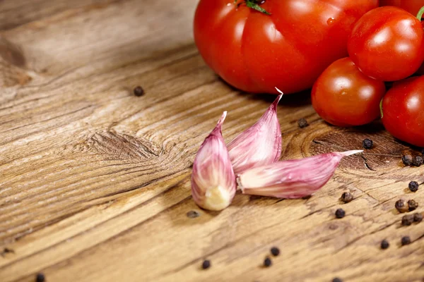 Pomodori, cipolle, pepe e aglio isolati sulla vecchia linguetta di legno — Foto Stock