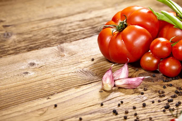 Pomodori, cipolle, pepe e aglio isolati sulla vecchia linguetta di legno — Foto Stock