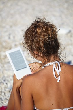 kadın tatilde plajda bir kitap okuma