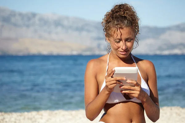 Frau im Urlaub am Strand liest ein Buch — Stockfoto