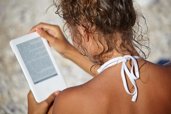 Frau im Urlaub am Strand liest ein Buch — Stockfoto