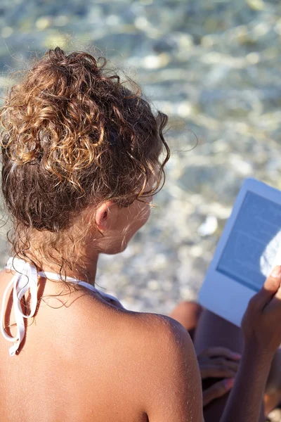 Nő a nyaralás a tengerparton, egy könyvet olvas — Stock Fotó