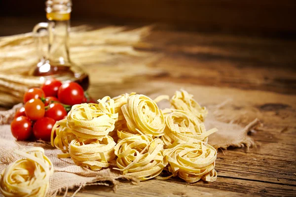Raw pasta,vegetables ,olive oil and spices — Stock Photo, Image