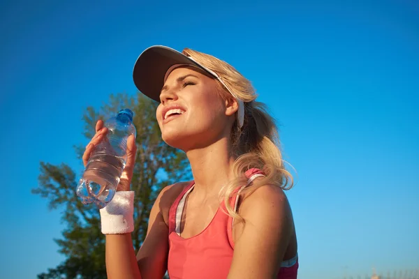 Mujer beber agua después de hacer deportes al aire libre —  Fotos de Stock