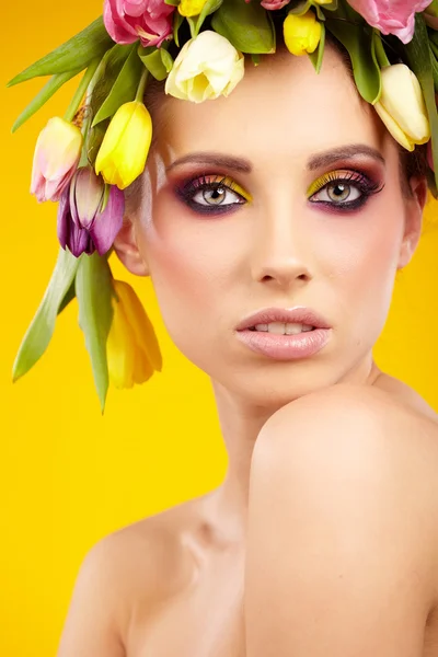 Ritratto di una bella ragazza primaverile che indossa un cappello di fiori. Studio. — Foto Stock