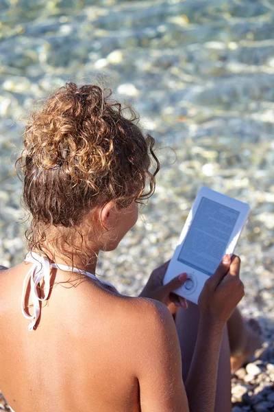 Frau liest eBook am Strand — Stockfoto