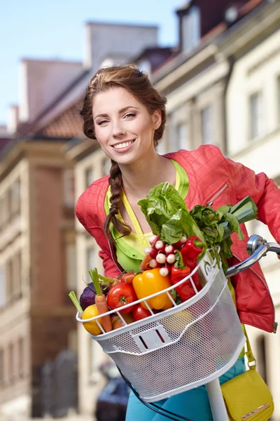 Mujer con bicicleta y comestibles — Foto de Stock