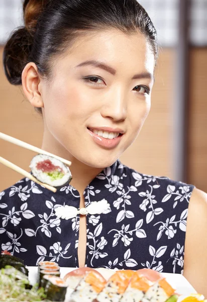 Frau isst Sushi mit Stäbchen — Stockfoto