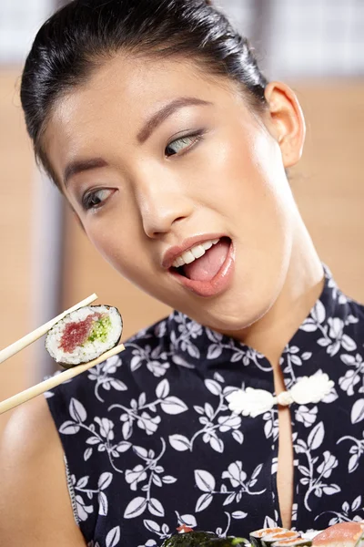 Vrouw sushi eten met stokjes — Stockfoto