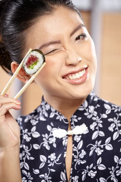 Žena s hůlkami jíst sushi — Stock fotografie