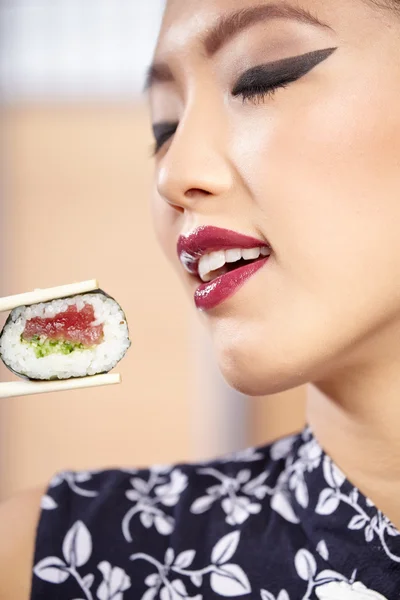 Mujer comiendo sushi con palillos —  Fotos de Stock