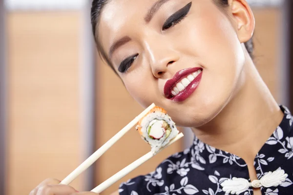 Vrouw sushi eten met stokjes — Stockfoto