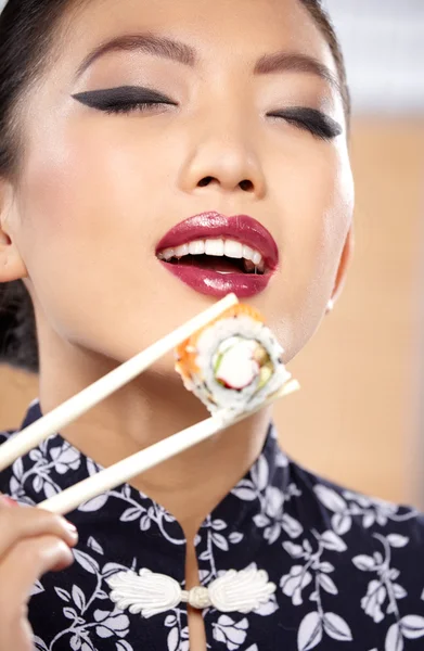 Vrouw sushi eten met stokjes — Stockfoto