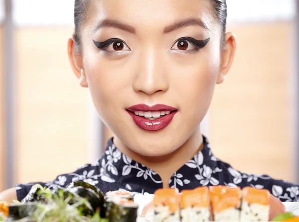 Woman showing a plate of sushi — Stock Photo, Image