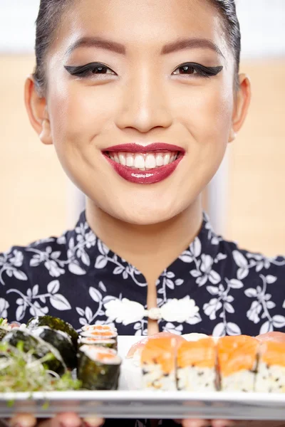 Woman showing a plate of sushi — Stock Photo, Image