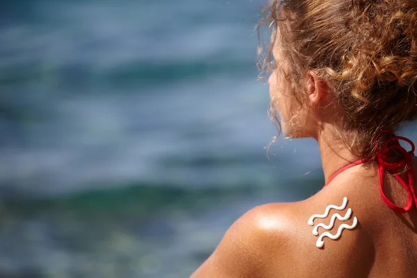 Woman with suntan lotion — Stock Photo, Image