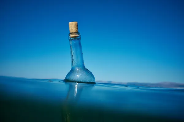 Bottle with a message in water — Stock Photo, Image