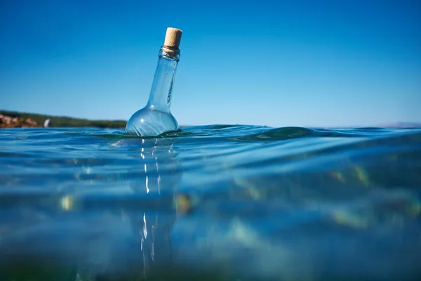 Fles met een bericht in water — Stockfoto