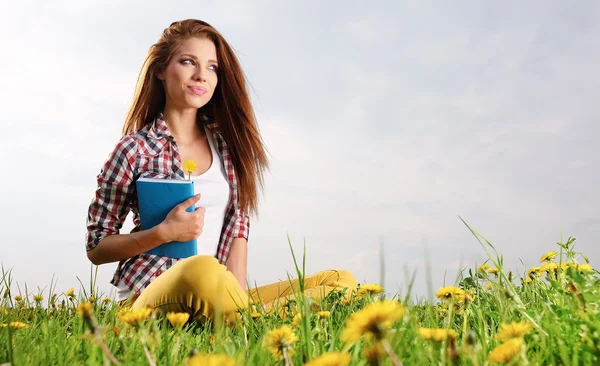 Woman on green field reading book — Stock Photo, Image