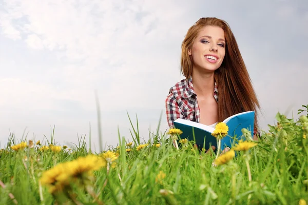 Woman on green field reading book — Stock Photo, Image