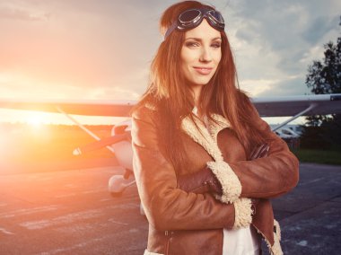 Woman pilot in front of airplane clipart