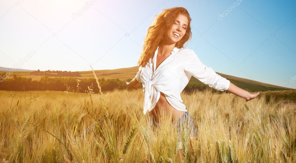 Lady in wheat field at sunset