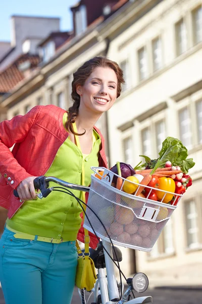 Frühlingsfrau mit Fahrrad und Lebensmitteln — Stockfoto