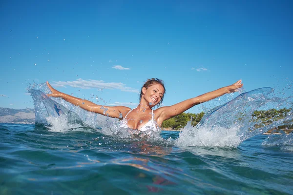 Modelo de roupa de banho salpicando água em férias — Fotografia de Stock