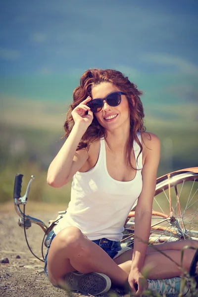 Menina vintage sentado ao lado de bicicleta — Fotografia de Stock